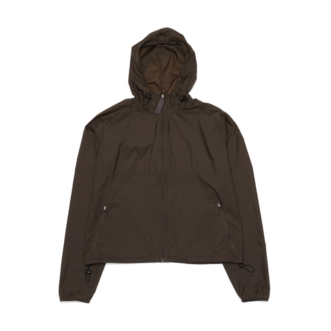 Women's ultra-lightweight running jacket (55g/m²) in Wren Brown. It features an adjustable hood, two side pockets, a back pocket, and side vents for enhanced ventilation. It is equipped with adjustable straps at the hem for a customizable fit. Made from 100% recycled nylon, it offers protection against wind and light rain. Additionally, it is packable, PFC-free, and features a reflective UNNA logo on the back, along with a UNNA patch on the zipper