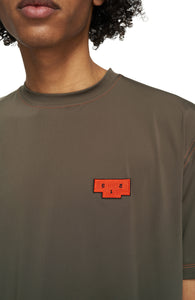 Men's T-shirt in Wren Brown with a regular fit and orange contrast seams. Made in an Italian lightweight fabric that has great absorbing quality and dries quickly. Patch with UNNA upside-down Podium Logo on the chest.