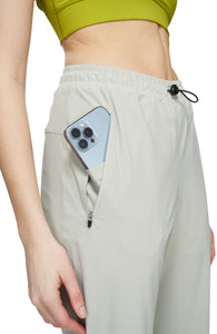 Women's running pants in Blonde Grey with a soft stretch, two front pockets and smart hidden pockets to keep your phone in place. Made in Econyl.