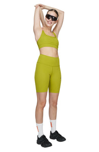 Sports bra in Golden Green with comfortable support, removable padding and adjustable strap. UNNA logo on the back. Made in Econyl.