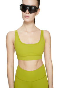 Sports bra in Golden Green with comfortable support, removable padding and adjustable strap. UNNA logo on the back. Made in Econyl.