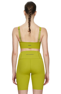 Sports bra in Golden Green with comfortable support, removable padding and adjustable strap. UNNA logo on the back. Made in Econyl.
