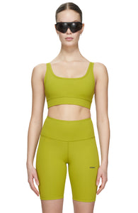 Sports bra in Golden Green with comfortable support, removable padding and adjustable strap. UNNA logo on the back. Made in Econyl.