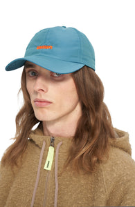 Petrol blue cap in shiny polyester with contrasting woven UNNA logo in front